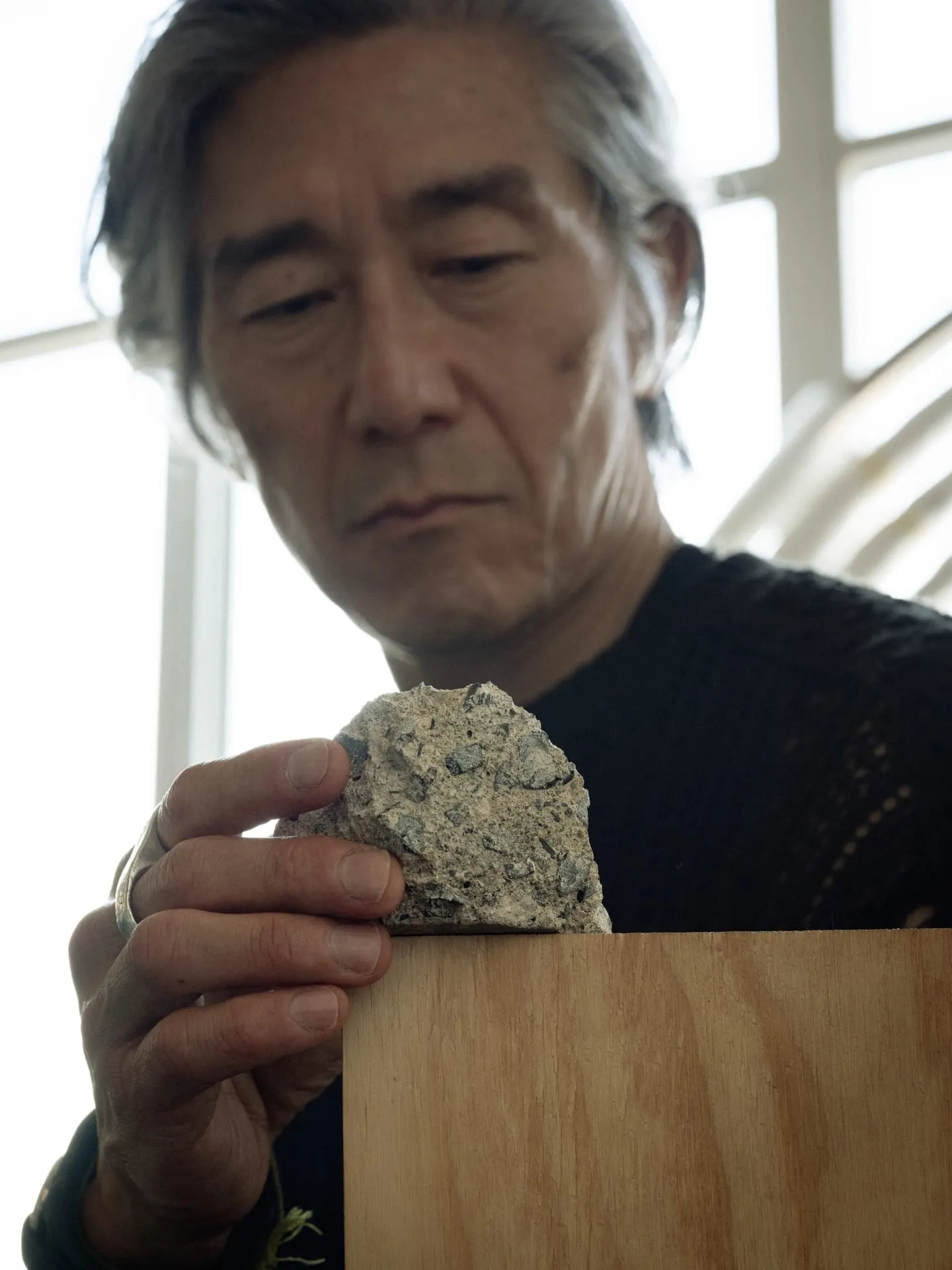 Joo handles a raw material in his Bushwick studio, where books sit alongside tools, construction hardware, and even scaffolding for his larger-scale works.