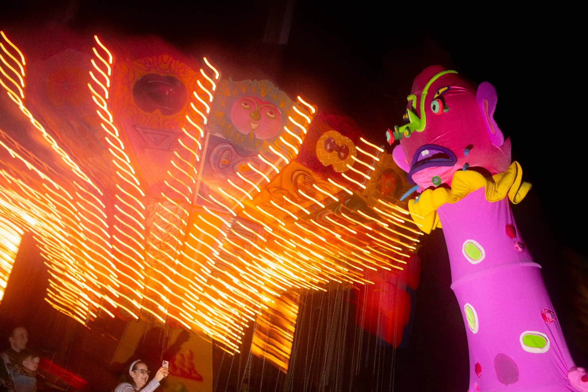 The pink monster looms over a guest as Kenny Scharf's carousel spins in the background at Luna Luna.