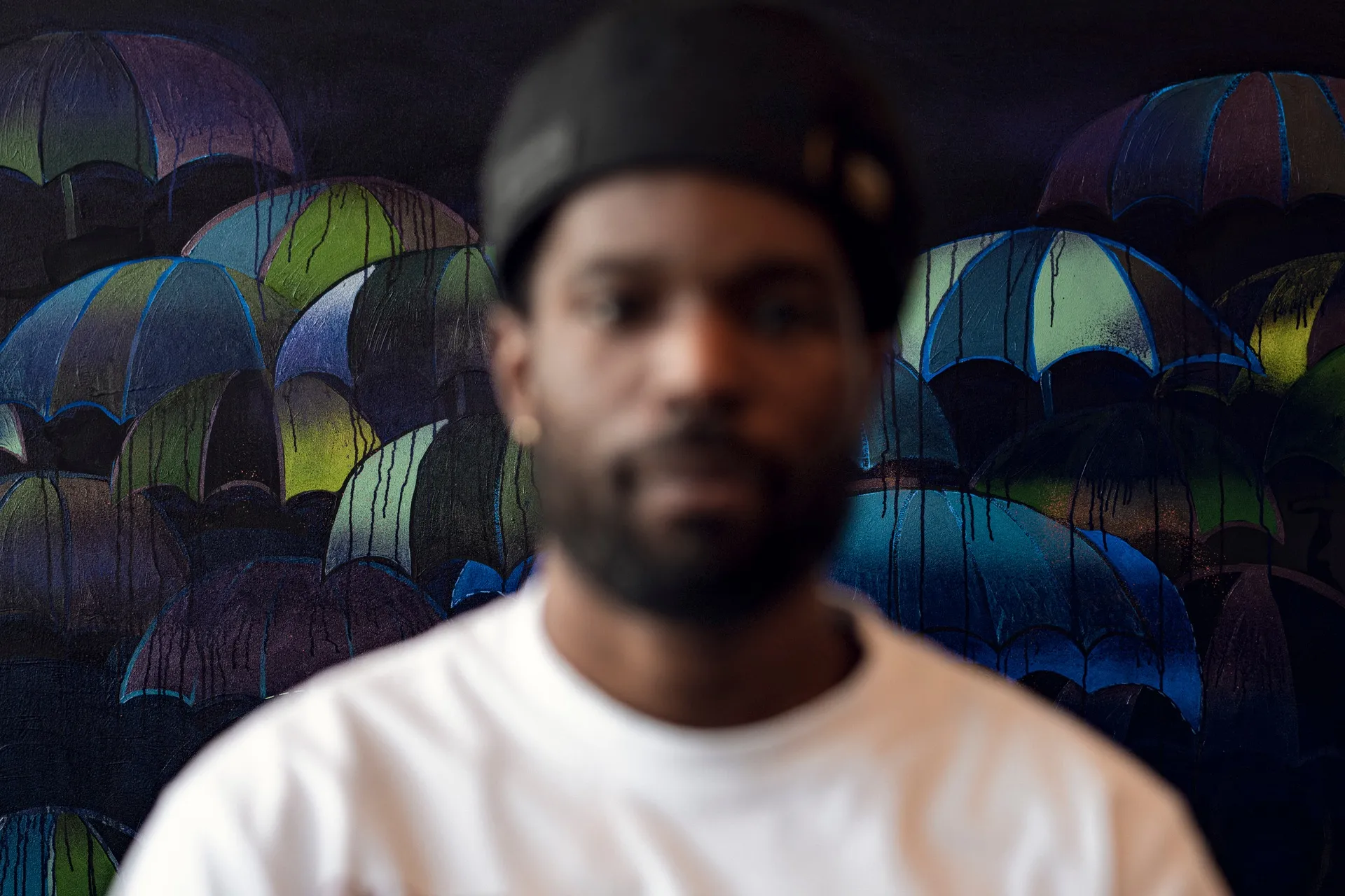 Mounting a painting featuring a crowd of silhouetted figures carrying umbrellas against a backdrop of rich blue, Price said, “I entered a flow state when I made this. I don’t think I could do this again.”